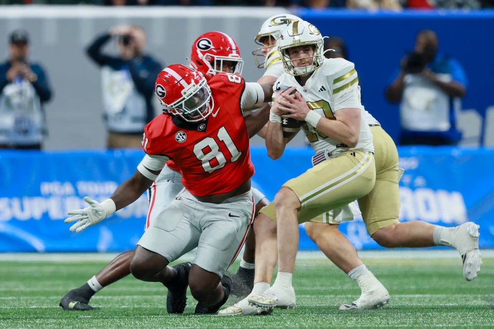 Georgia Tech quarterback Haynes King (right) makes a move against Georgia defensive lineman Josh Horton at Mercedes-Benz Stadium on Friday, Nov. 28, 2025, in Atlanta. (Jason Getz/AJC)
