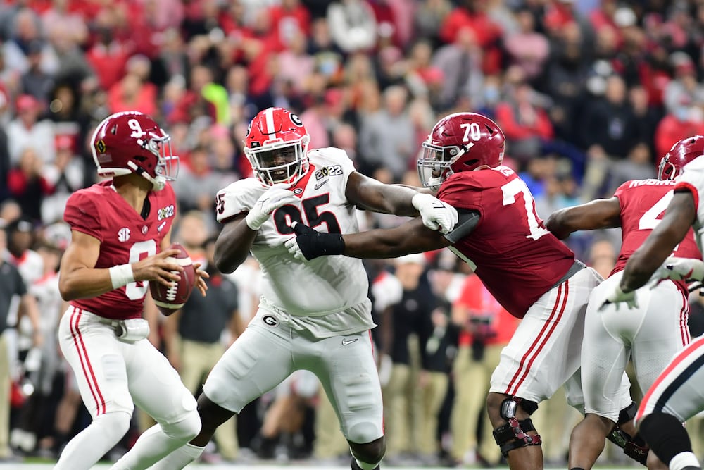 Georgia defensive lineman Devonte Wyatt (center) works to reach Alabama quarterback Bryce Young during their 2021 College Football Playoff championship game on Monday, Jan. 10, 2022, at Lucas Oil Stadium in Indianapolis. (Perry McIntyre/UGA Sports Communications)