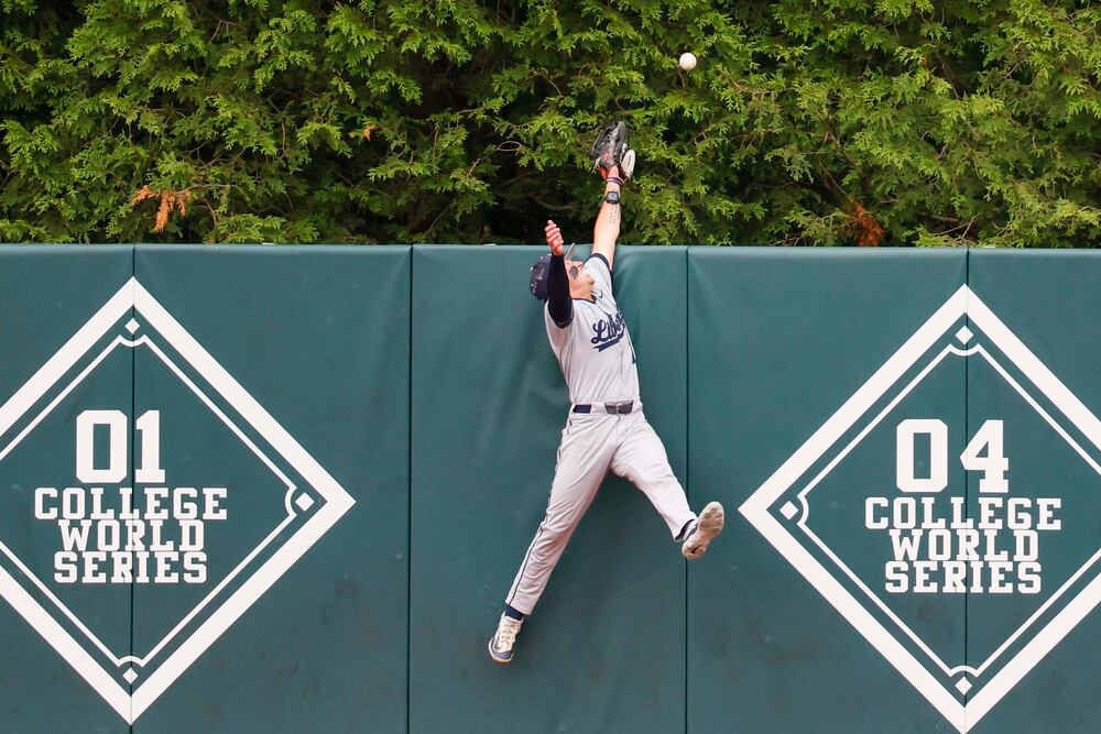 Liberty Flames outfielder Nick Barone (17) cannot catch the ball from Georgia Bulldogs infielder Tre Phelps (1) during a 2-run home run in the sixth inning of their NCAA Regional final game at Foley Field on Sunday, May 31, 2026, in Athens. (Miguel Martinez/AJC)