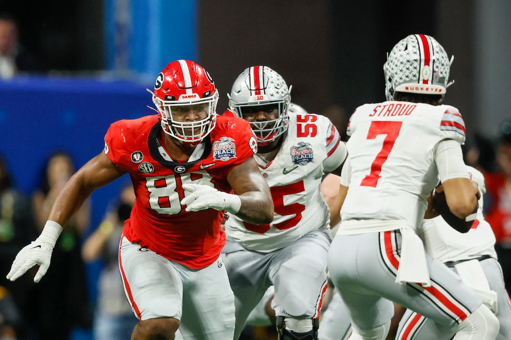 Georgia defensive lineman Jalen Carter (left) pursues Ohio State quarterback C.J. Stroud during the first half of the Peach Bowl at Mercedes-Benz Stadium on Saturday, Dec. 31, 2022, in Atlanta. (Jason Getz/AJC)