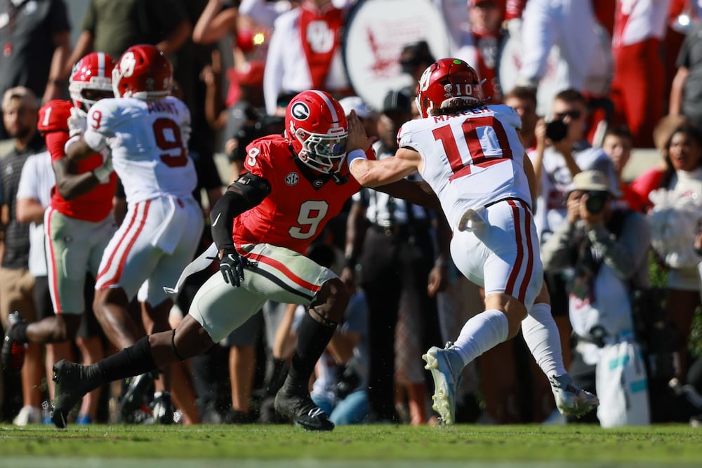 Georgia linebacker Chris Cole (center left) tackles Oklahoma quarterback John Mateer during the second quarter of their football game, Saturday, Sept. 26, 2026. (Jason Getz/AJC)