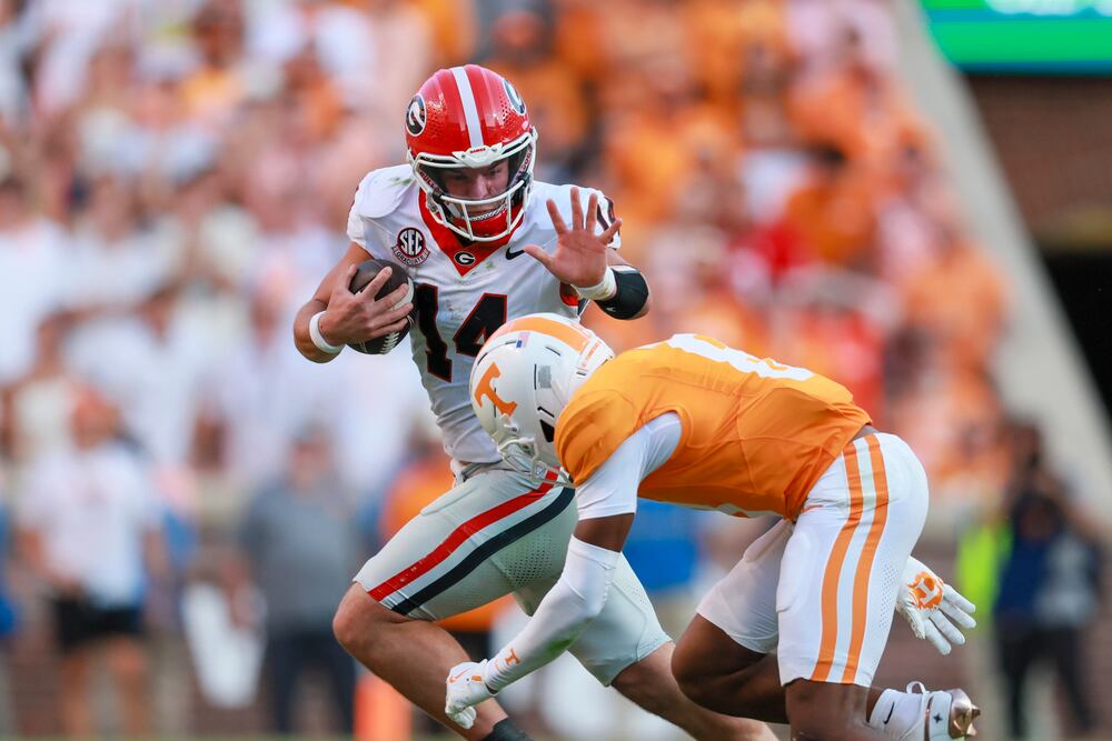 Georgia quarterback Gunner Stockton (14) runs against Tennessee defensive back Colton Hood (8) for yards during the fourth quarter at Neyland Stadium, Saturday, September 13, 2025, in Knoxville, Tenn. Georgia won 44-41 in overtime. (Jason Getz / AJC)
