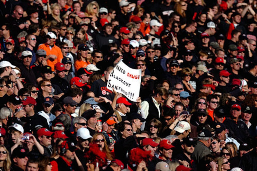 A fan holds a Crazed Dawgs Blackout Sanford sign during the 2007 blackout game. (Pouya Dianat/AJC)