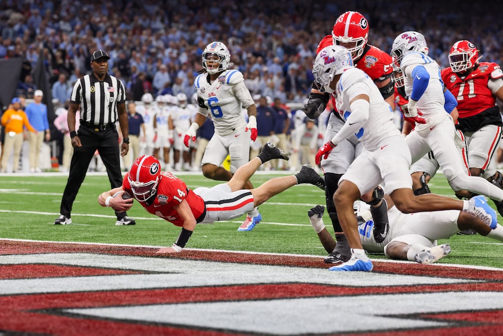 Georgia quarterback Gunner Stockton (left) dives into the end zone for a 12-yard touchdown run against Ole Miss during the Sugar Bowl at the Caesars Superdome on Thursday, Jan. 1, 2026, in New Orleans. (Jason Getz/AJC)