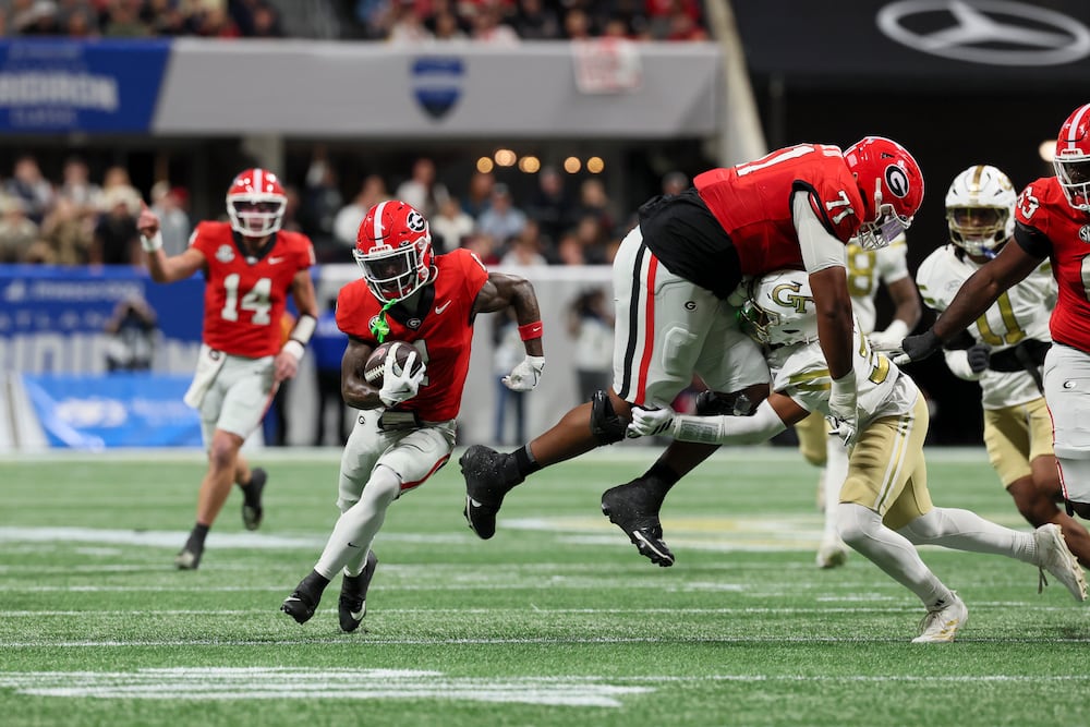 Georgia wide receiver Zachariah Branch (left) runs after a reception as offensive lineman Earnest Greene III blocks a Georgia Tech defender at Mercedes-Benz Stadium on Friday, Nov. 28, 2025, in Atlanta. (Jason Getz/AJC)