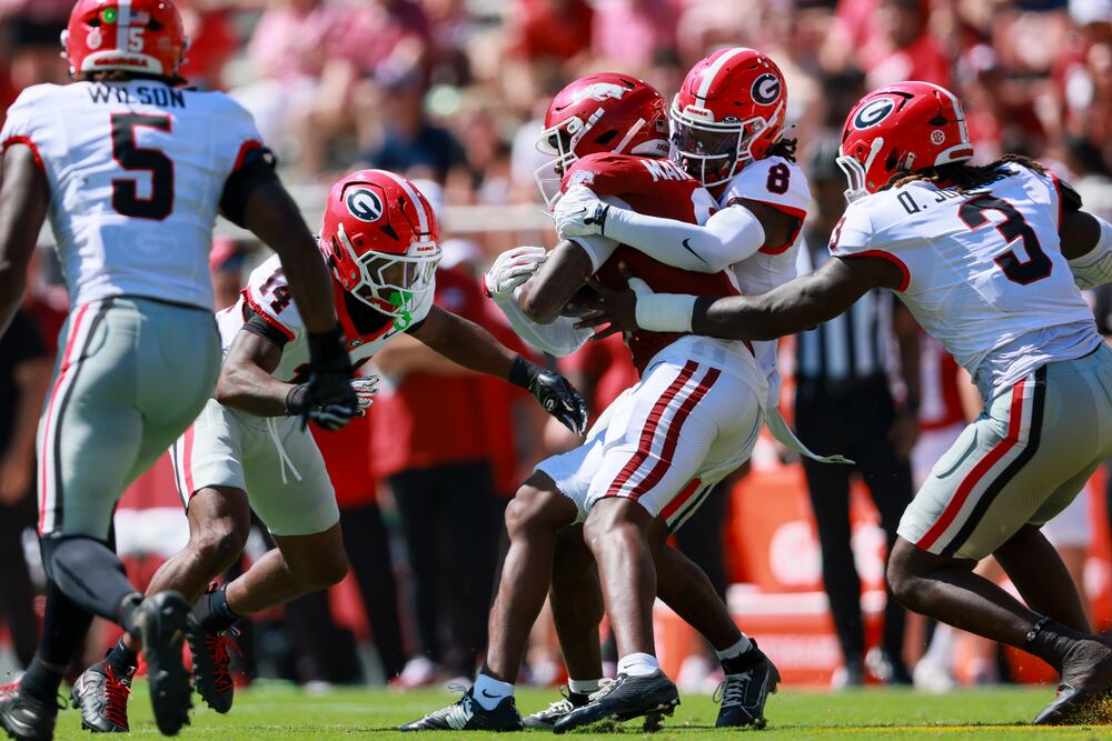 Georgia defensive back Demello Jones tackles Arkansas wide receiver Chris Marshall after a catch by Marshall during the first half. (Jason Getz/AJC)