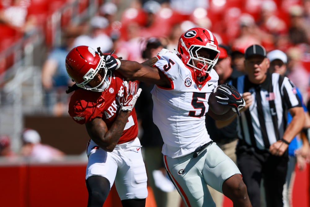 Georgia running back Chauncey Bowens (right) moves past Arkansas defensive back Shelton Lewis for a first down at Donald W. Reynolds Razorback Stadium on Saturday, Sept. 19, 2026, in Fayetteville, Ark. (Jason Getz/AJC)