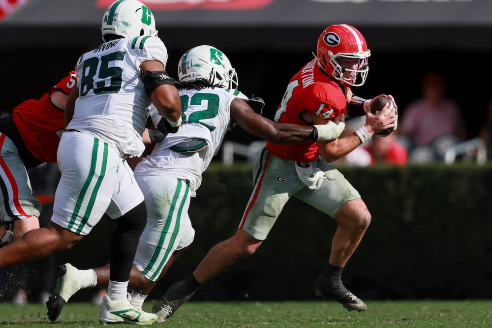 Georgia quarterback Gunner Stockton (right) is sacked by Charlotte defensive lineman Curtis Simpson at Sanford Stadium on Friday, Nov. 22, 2025, in Athens. (Jason Getz/AJC)