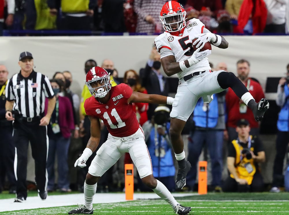 Georgia defensive back Kelee Ringo (right) intercepts a Bryce Young pass and returns it for a touchdown. (Curtis Compton/AJC 2022)