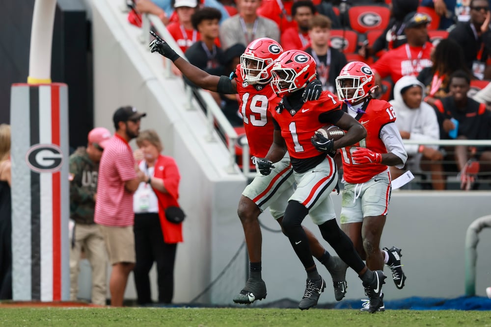 Georgia defensive back Ellis Robinson IV (front) celebrates his interception against Kentucky with linebacker Justin Williams (left) at Sanford Stadium on Saturday, Oct. 4, 2025, in Athens. (Jason Getz/AJC)