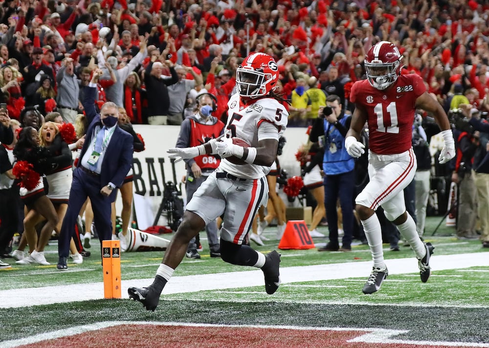 Georgia defensive back Kelee Ringo (left) intercepts Alabama and returns it for a touchdown during their College Football Playoff championship game on Monday, Jan. 10, 2022, in Indianapolis. (Curtis Compton/AJC)