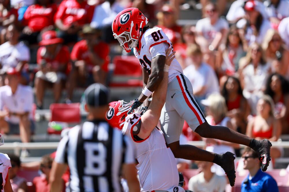 Georgia offensive lineman Drew Bobo picks up wide receiver Craig Dandridge Jr. after the latter's 61-yard touchdown reception. (Jason Getz/AJC)