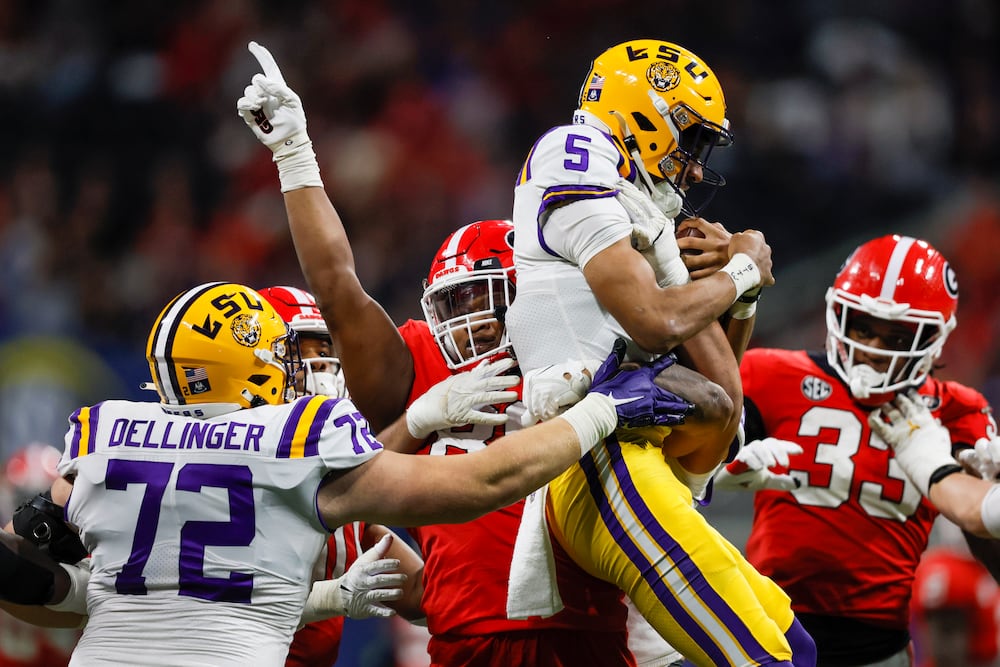 Georgia defensive lineman Jalen Carter lifts up LSU quarterback Jayden Daniels in 2022. (Jason Getz/AJC)