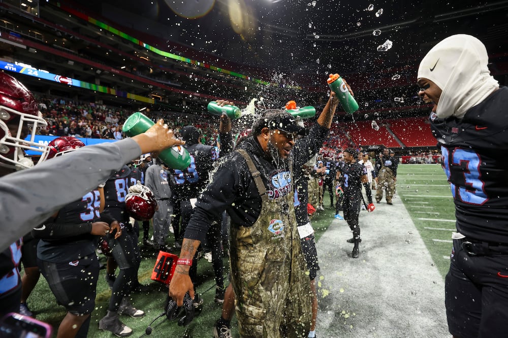 Carver-Columbus head coach Jarvis Jones celebrates with players after their 24-7 win against Hapeville Charter in the Class 2A GHSA football championship at Mercedes-Benz Stadium, Tuesday, Dec. 16, 2025, in Atlanta. (Jason Getz/AJC)