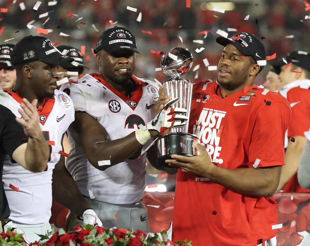 Sony Michel (from left), Roquan Smith and Nick Chubb celebrate with the Rose Bowl trophy following Georgia's 54-48 double-overtime win over Oklahoma on Monday, Jan. 1, 2018, in Pasadena, Calif. (Curtis Compton/AJC)