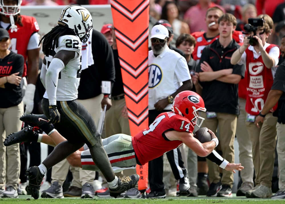 Georgia quarterback Gunner Stockton (14) dives near the endzone for extra yardage. (Hyosub Shin/AJC)