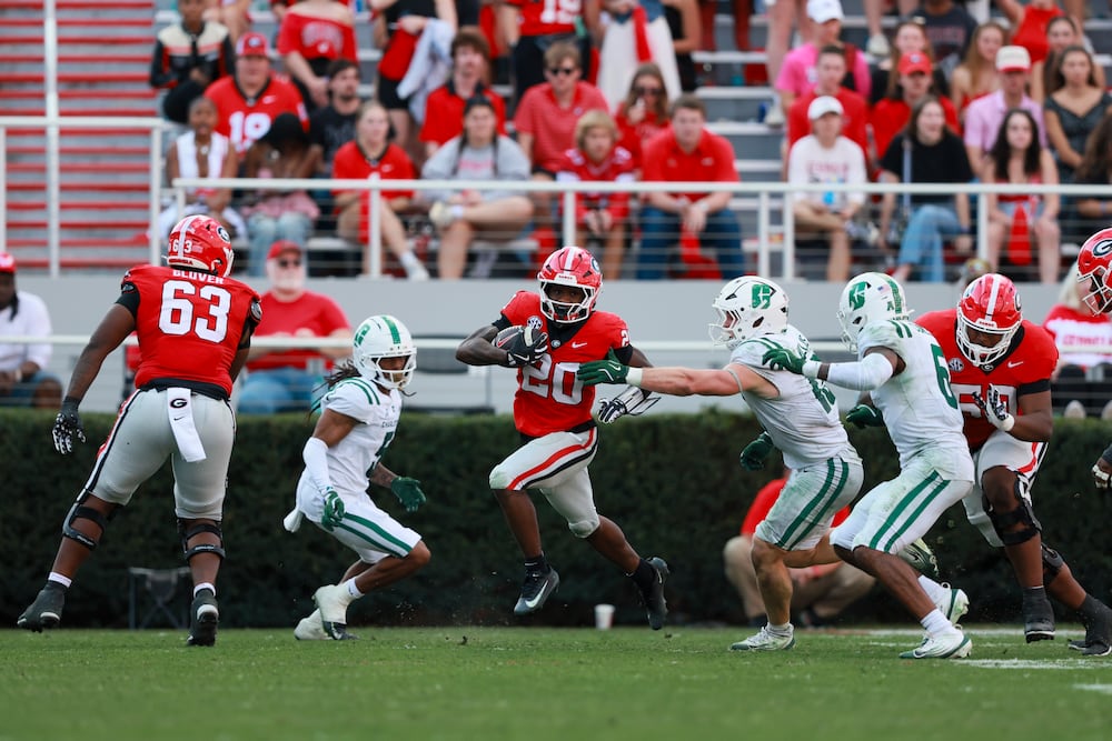 Georgia running back Dwight Phillips Jr. (center) runs for yards against Charlotte in November in Athens. (Jason Getz/AJC 2025)
