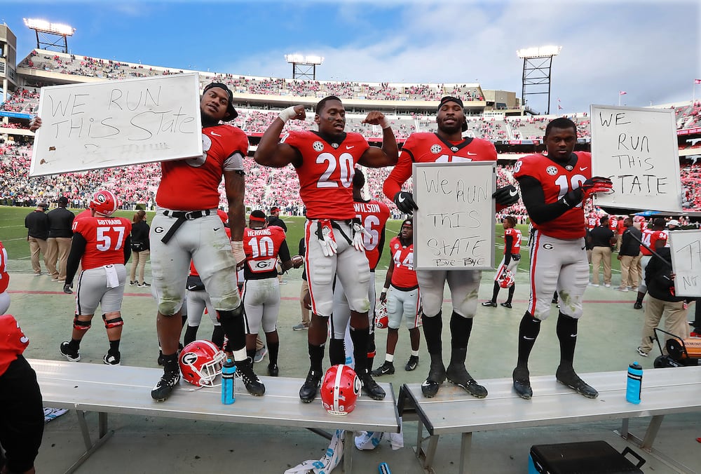 Georgia players (from left) Jonathan Ledbetter, J.R. Reed, DAndre Walker, and Deandre Baker celebrate beating Georgia Tech 45-21 in the final minutes of their college football rivalry game on Saturday, Nov. 24, 2018, in Athens. (Curtis Compton/AJC)
