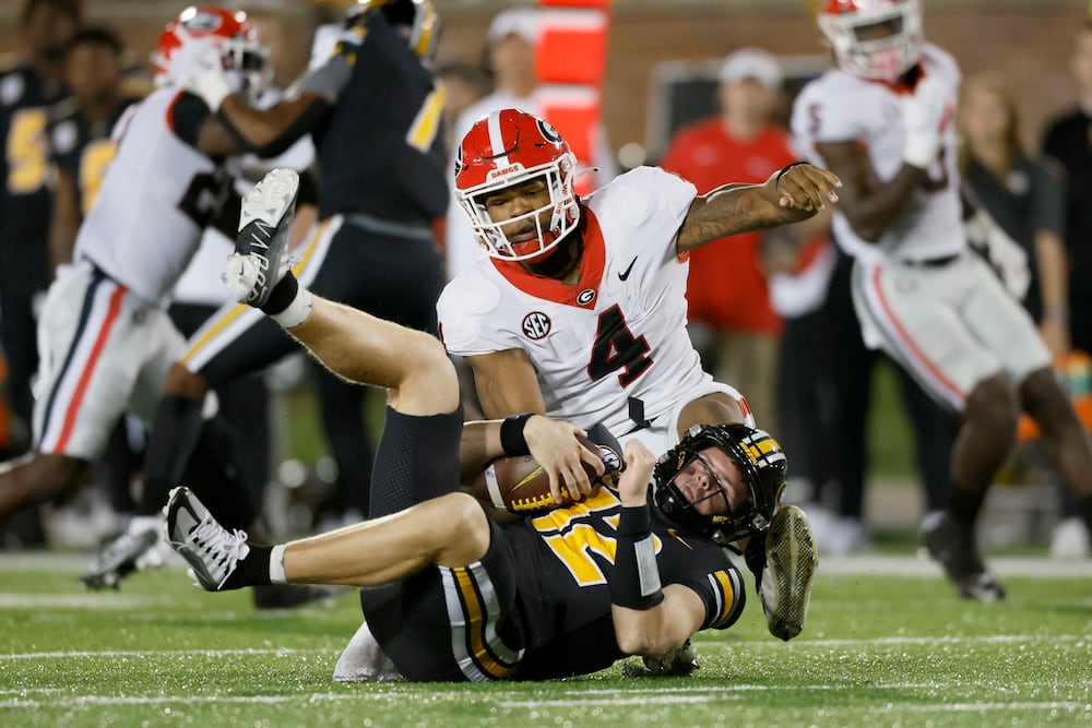 Georgia linebacker Nolan Smith (top) sacks Missouri quarterback Brady Cook at Memorial Stadium on Saturday, Oct. 1, 2022, in Columbia, Mo. (Jason Getz/AJC)