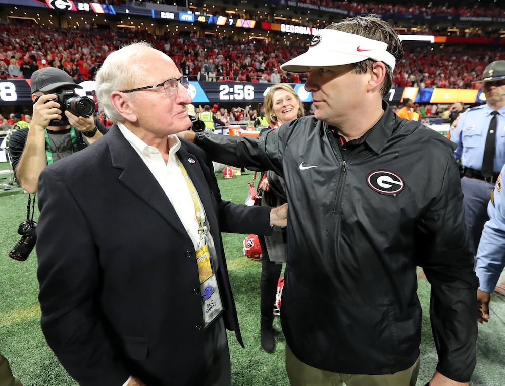 Former Georgia athletic director and coach Vince Dooley (left) and coach Kirby Smart share a moment after the Bulldogs defeated Auburn in the SEC Championship in 2017. (Curtis Compton/AJC)
