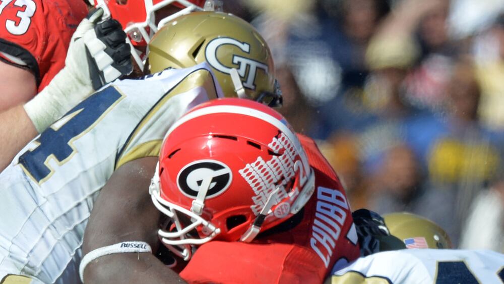Georgia Bulldogs running back Nick Chubb (27) is brought down by Georgia Tech Yellow Jackets linebacker Quayshawn Nealy (54) and Georgia Tech Yellow Jackets linebacker Paul Davis (40) for in the first half at Sanford Stadium in Athens on Saturday, Nov. 29, 2014.