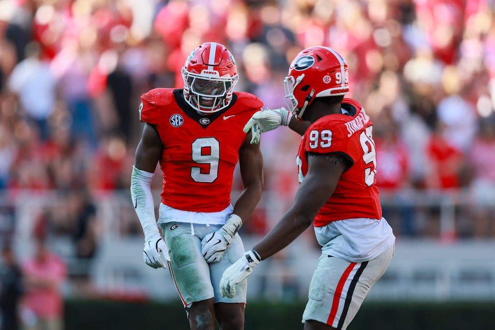Georgia linebacker Chris Cole (left) celebrates a sack with defensive lineman Joseph Jonah-Ajonye during the second half against Charlotte at Sanford Stadium on Friday, Nov. 22, 2025, in Athens.