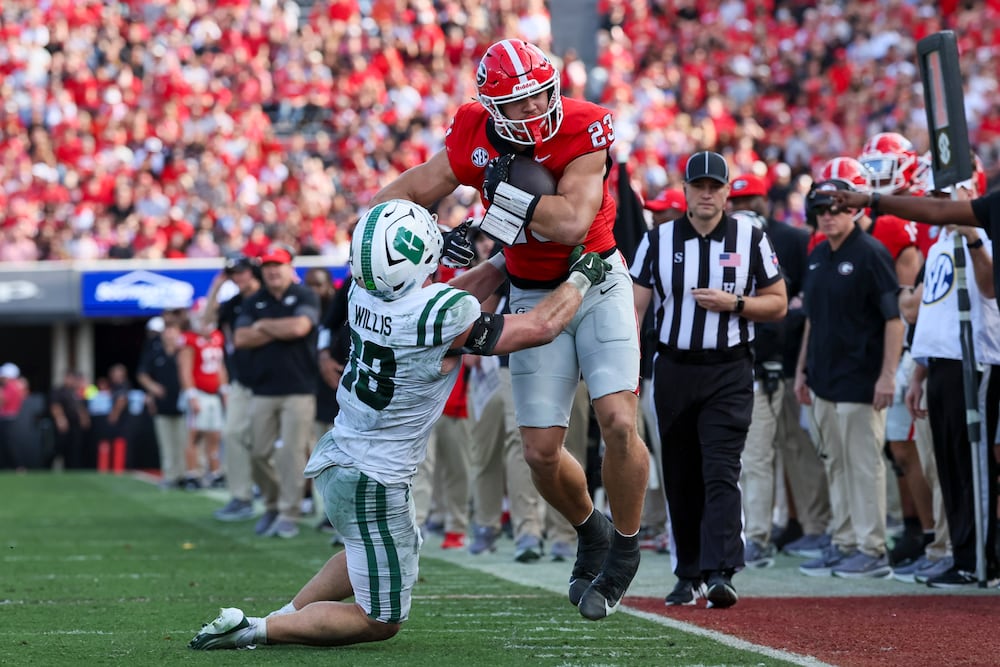 Georgia tight end Jaden Reddell (right) is tackled by Charlotte linebacker Gavin Willis at Sanford Stadium on Friday, Nov. 22, 2025, in Athens. (Jason Getz/AJC)