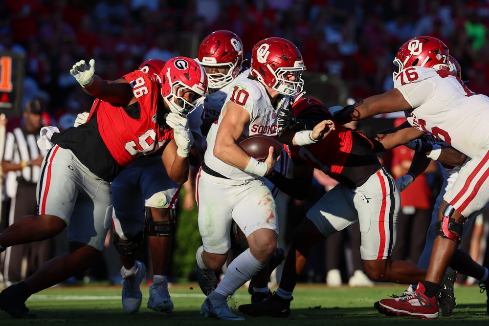 Georgia defensive lineman JJ Hanne (left) pressures Oklahoma quarterback John Mateer (center) during the fourth quarter. (Jason Getz/AJC)
