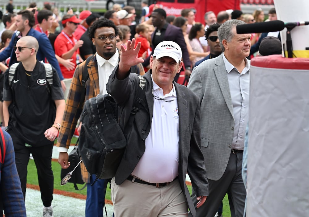 Georgia offensive coordinator Mike Bobo waves as players and coaching staff arrive to Sanford Stadium before their game against Mississippi on Saturday, Oct. 18, 2025, in Athens. (Hyosub Shin/AJC)