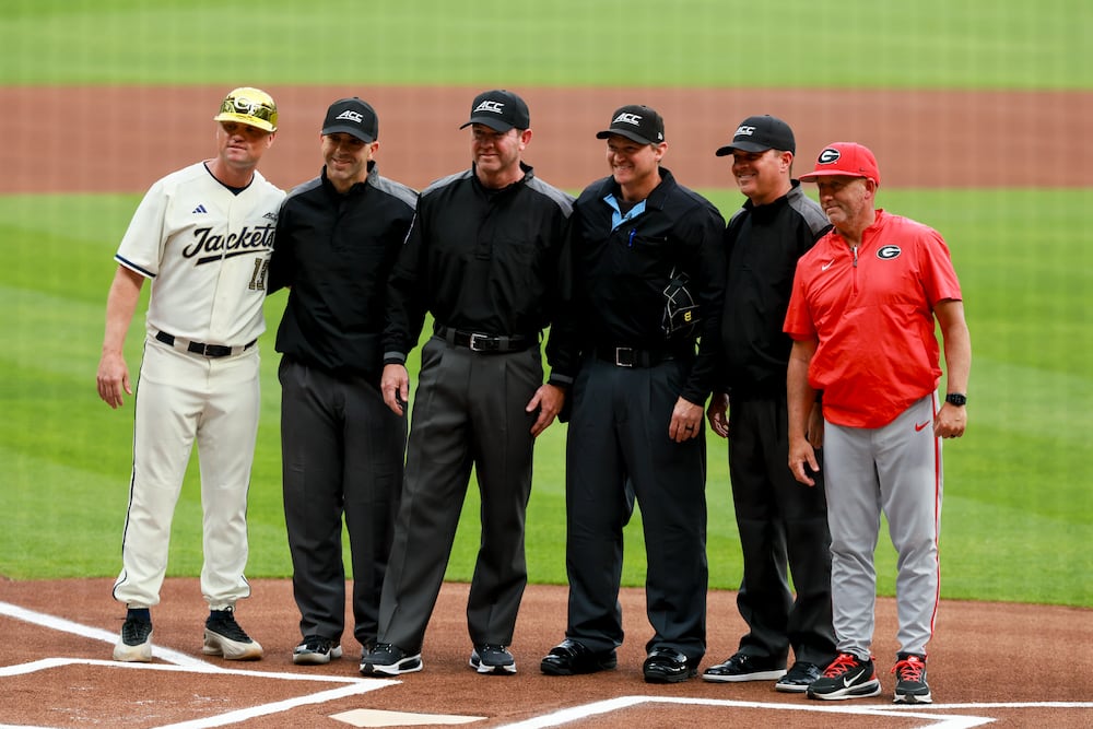 Georgia Tech head coach James Ramsey (left) and Georgia head coach Wes Johnson pose with umpires before their NCAA baseball game at Truist Park on Tuesday, April 21, 2026, in Atlanta. (Jason Getz/AJC)