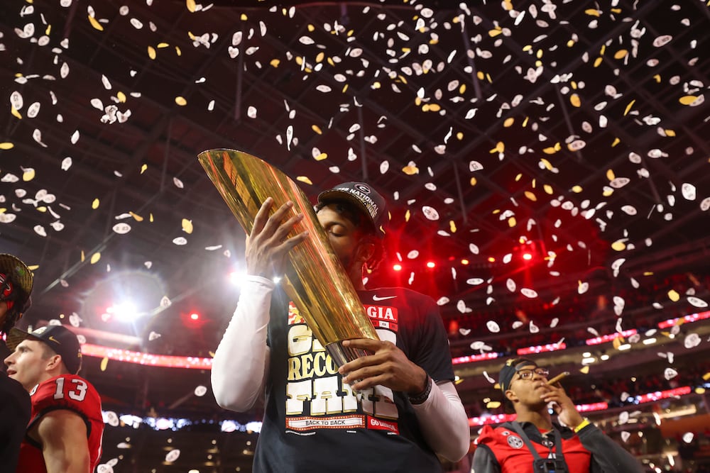 Georgia defensive back Christopher Smith kisses the trophy after Georgias win against TCU in the 2023 College Football Playoff National Championship at SoFi Stadium, in Los Angeles. Georgia won 65-7. (Jason Getz/AJC)