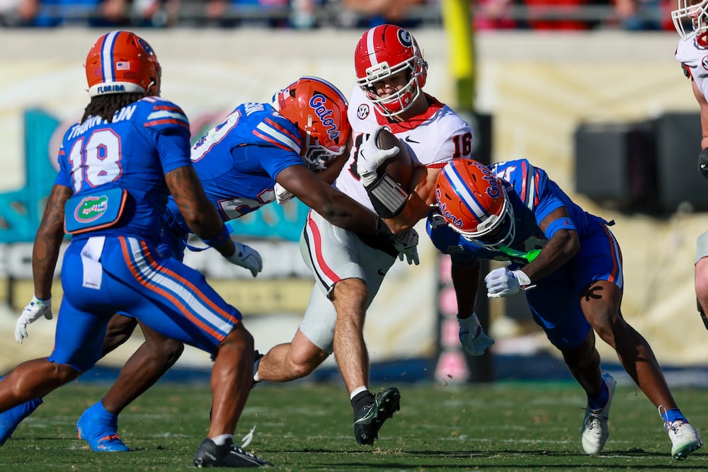 Georgia wide receiver London Humphreys (second from right) is tackled by Florida linebacker Jaden Robinson (second from left) and safety Jordan Castell (right) after a catch by Humphrey during the first half in their NCAA game at EverBank Stadium, Saturday, Nov. 1, 2025, in Jacksonville, Fla. (Jason Getz/AJC)