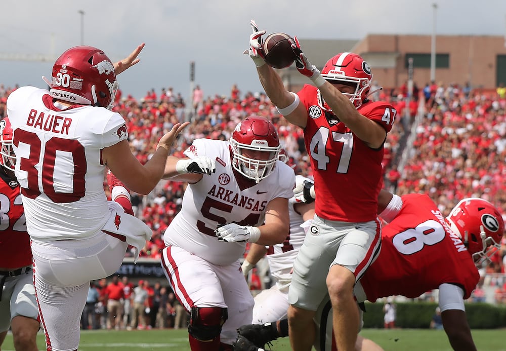 Georgia defensive back Dan Jackson (right) blocks the punt in the endzone by Arkansas kicker Reid Bauer, causing Georgia to recover for the touchdown to take a 21-0 lead during the first quarter on Saturday, Oct. 2, 2021, in Athens. (Curtis Compton/AJC)