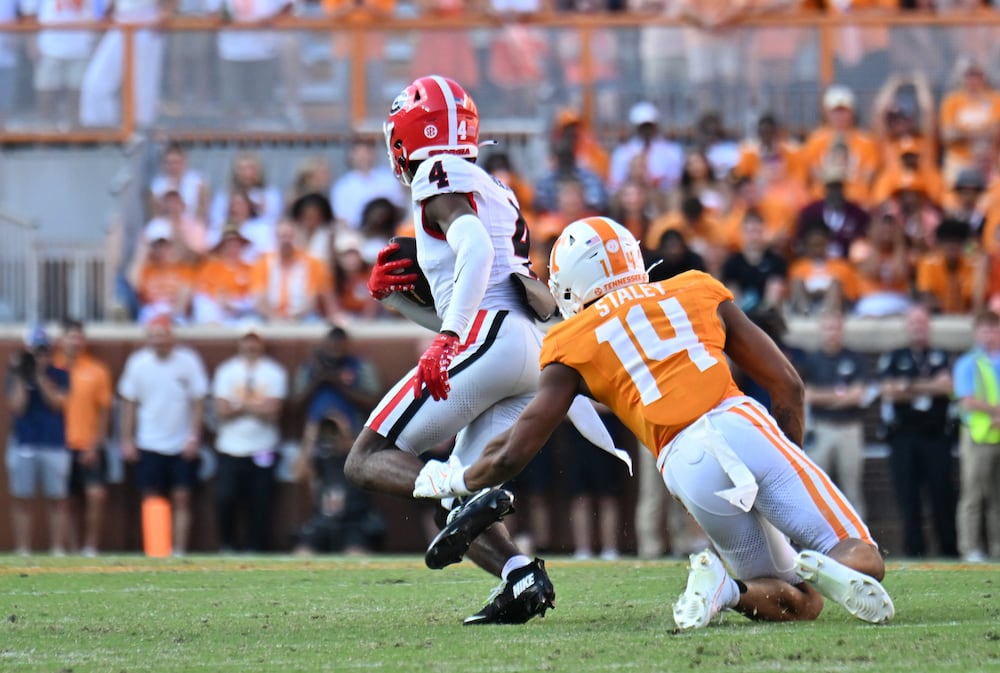 Georgia defensive back KJ Bolden (left) runs after recovering a fumble against Tennessee in September in Knoxville, Tenn. (Hyosub Shin/AJC 2025)