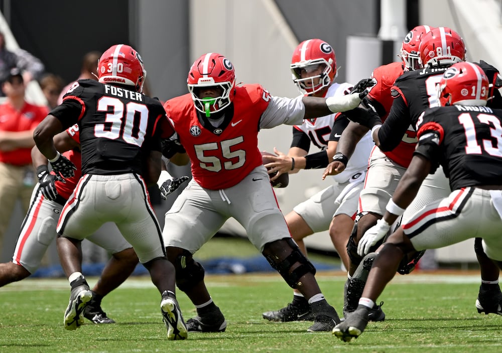 Georgia center Zykie Helton (center left) blocks for quarterback Ryan Montgomery (center right, back) during the G-Day spring football game in April in Athens. (Hyosub Shin/AJC)