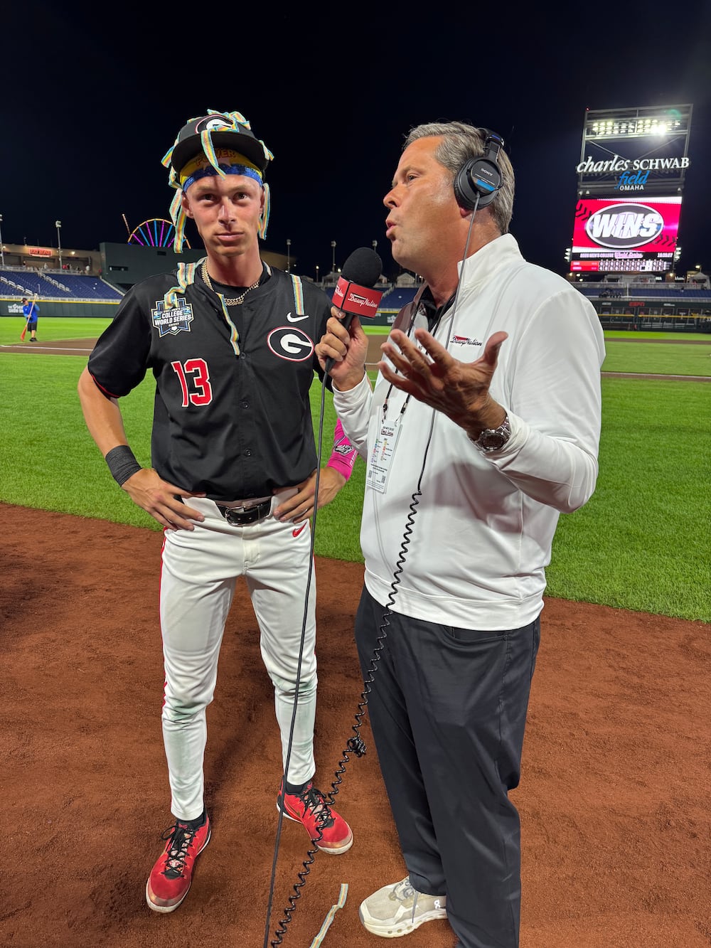 Dawgnation's Brandon Adams (right) interviews Scott Newman, originator of Georgia's Sour Power celebration, after the Bulldogs' 7-1 win vs. Texas in the College World Series on Saturday, June 13, 2026, in Omaha, Nebraska. (Sarah Spencer/AJC)