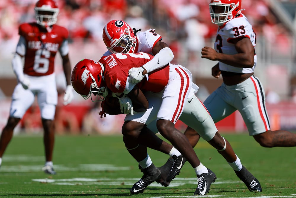 Georgia linebacker Chris Cole tackles Arkansas quarterback AJ Hill during the first of Saturday's game. (Jason Getz/AJC)
