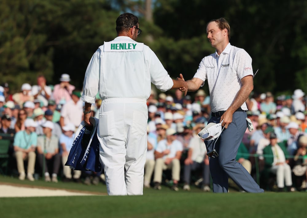 Russell Henley greets his caddie Andrew Sanders at the end of the final round of the Masters, at Augusta National Golf Club, Sunday, April 12, 2026, in Augusta. (Jason Getz/AJC)