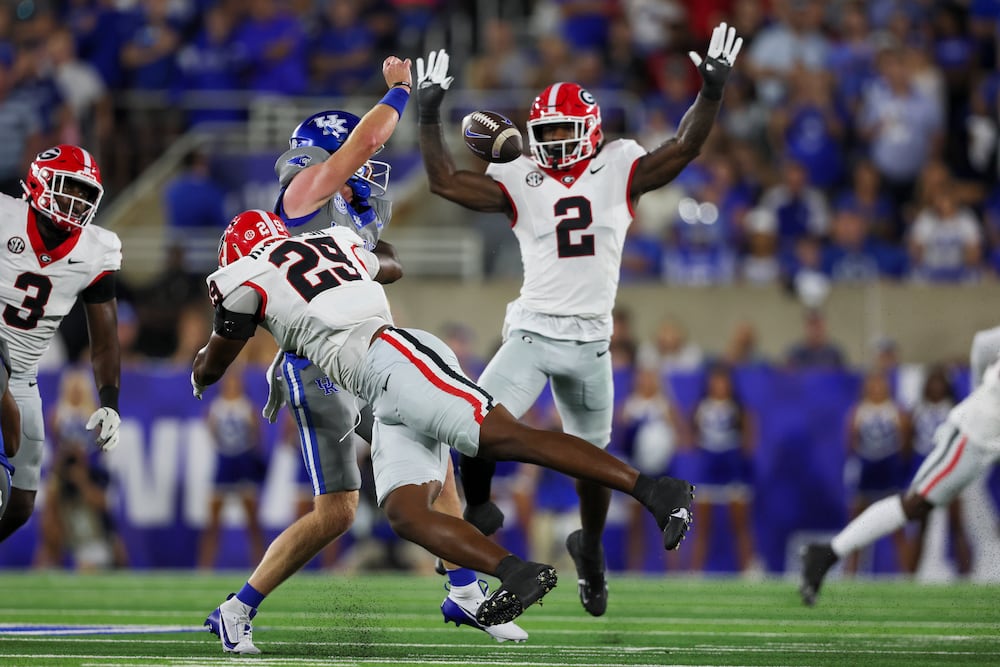 Georgia linebacker Gabe Harris Jr. (center) causes Kentucky quarterback Brock Vandagriff to fumble the ball as Georgia linebacker Smael Mondon Jr. jumps nearby during the first half at Kroger Field on Saturday, Sept. 14, 2024, in Lexington, Ky. (Jason Getz/AJC)