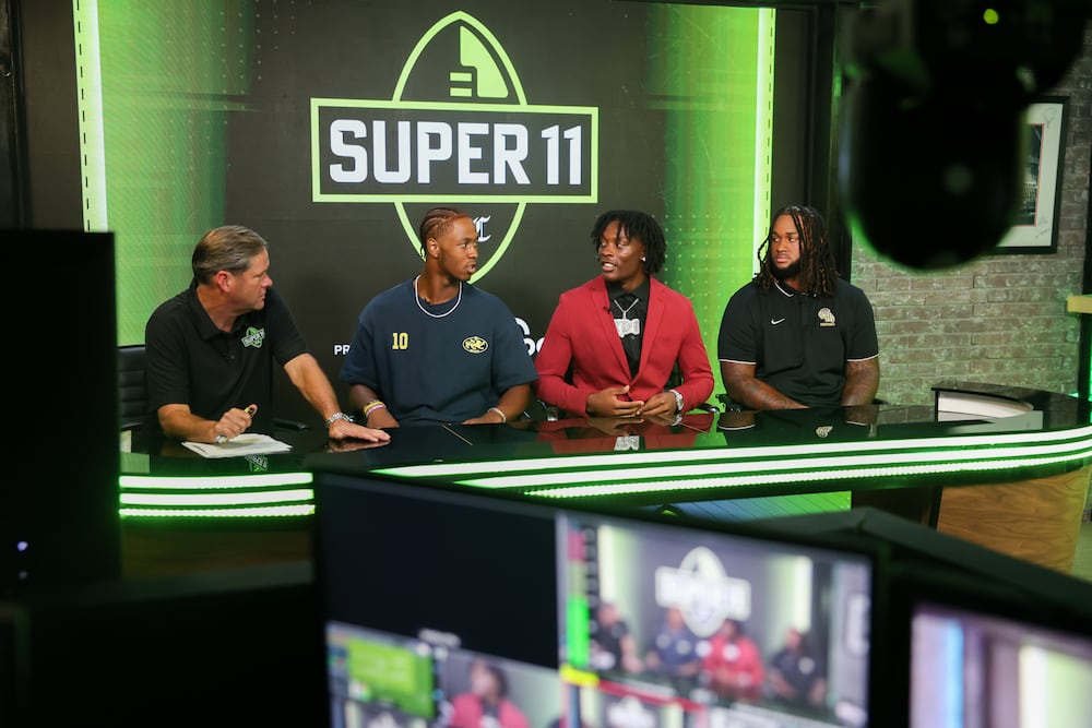 DawgNations Brandon Adams (from left) interviews Stephensons Kwame KJ Green Jr., Hamptons Kamarui Dorsey and Hughes Kelsey Adams Jr. during the taping of the Super 11 reveal show at Score ATL in Roswell on Monday, Aug. 3, 2026. (Arvin Temkar/AJC)