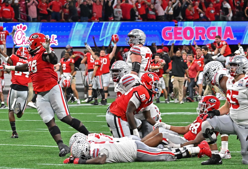Georgia players and coaching staff celebrate after Ohio State place kicker Noah Ruggles fails to score the final field goal during the Chick-fil-A Peach Bowl on Saturday, Dec. 31, 2022, in Atlanta. (Hyosub Shin/AJC)