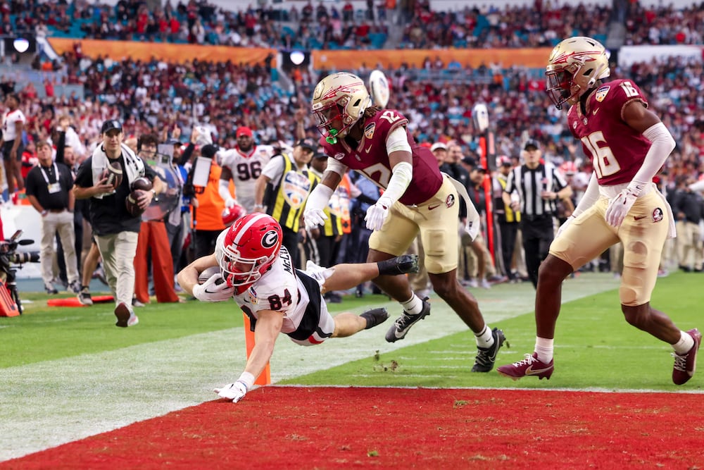 Georgia wide receiver Ladd McConkey (left) dives for a touchdown against Florida State defensive back Conrad Hussey during the Orange Bowl at Hard Rock Stadium on Saturday, Dec. 30, 2023, in Miami Gardens, Fla. (Jason Getz/AJC)