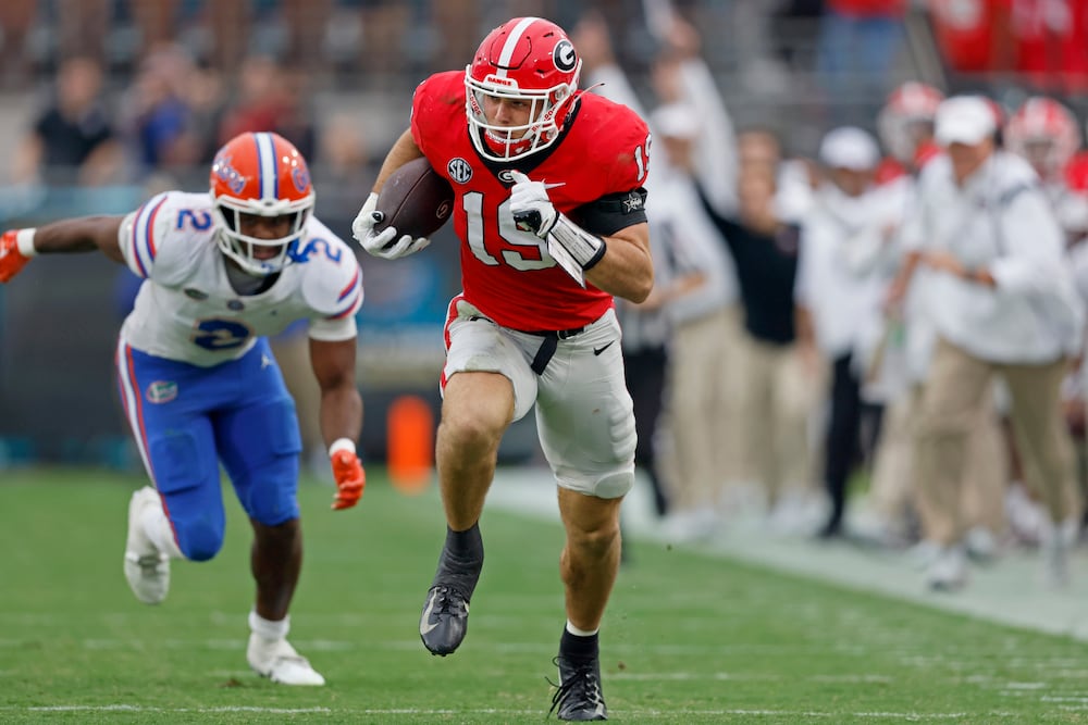 Georgia tight end Brock Bowers (center) runs after making a bobbled catch against Florida linebacker Amari Burney for a 73-yard touchdown in 2022. (Jason Getz/AJC)