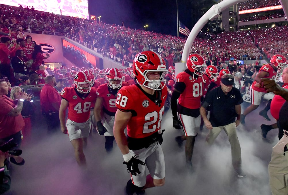 Georgia coach Kirby Smart (right) and his players run onto the field before their game against Texas at Sanford Stadium on Saturday, Nov. 15, 2025, in Athens. (Hyosub Shin/AJC)