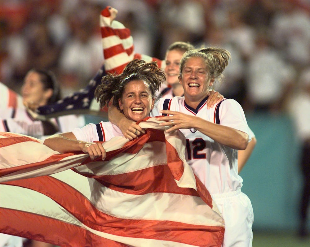 Soccer players Joy Fawcett (left) and Carin Gabarra run around Sanford Stadium with an American flag after their historic gold-medal win over China during the 1996 Summer Olympics on Thursday, Aug. 1, 1996, in Athens. (David Tulis/AJC file)