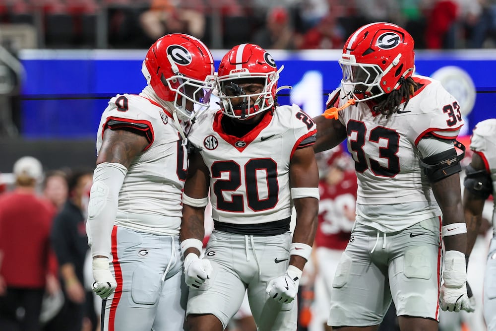 Georgia defensive back JaCorey Thomas (center) celebrates with linebackers Gabe Harris Jr. (left) and Quintavius Johnson after Thomas sacked Alabama quarterback Ty Simpson for a 9-yard loss during the SEC championship game at Mercedes-Benz Stadium on Saturday, Dec. 6, 2025, in Atlanta.