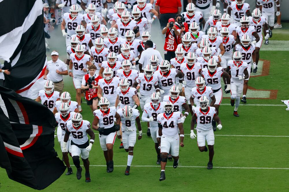 Georgia football players runs onto the field before their NCAA football game against Western Kentucky at Sanford Stadium, Saturday, Sept. 12, 2026, in Athens, Ga. (Jason Getz/AJC)