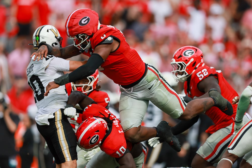 Vanderbilt quarterback Whit Muschamp is pressured on a pass attempt by Georgia linebackers Gabe Harris Jr. and Zayden Walker. (Jason Getz/AJC)