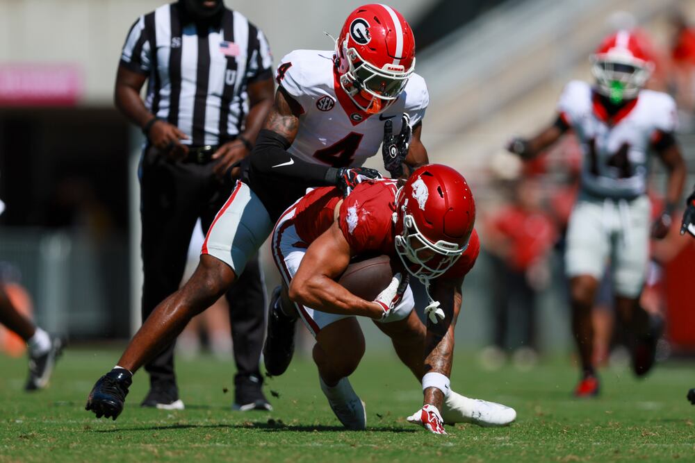 Georgia defensive back KJ Bolden tackles Arkansas wide receiver Donovan Faupel after a short reception by Faupel during the first half. (Jason Getz/AJC)