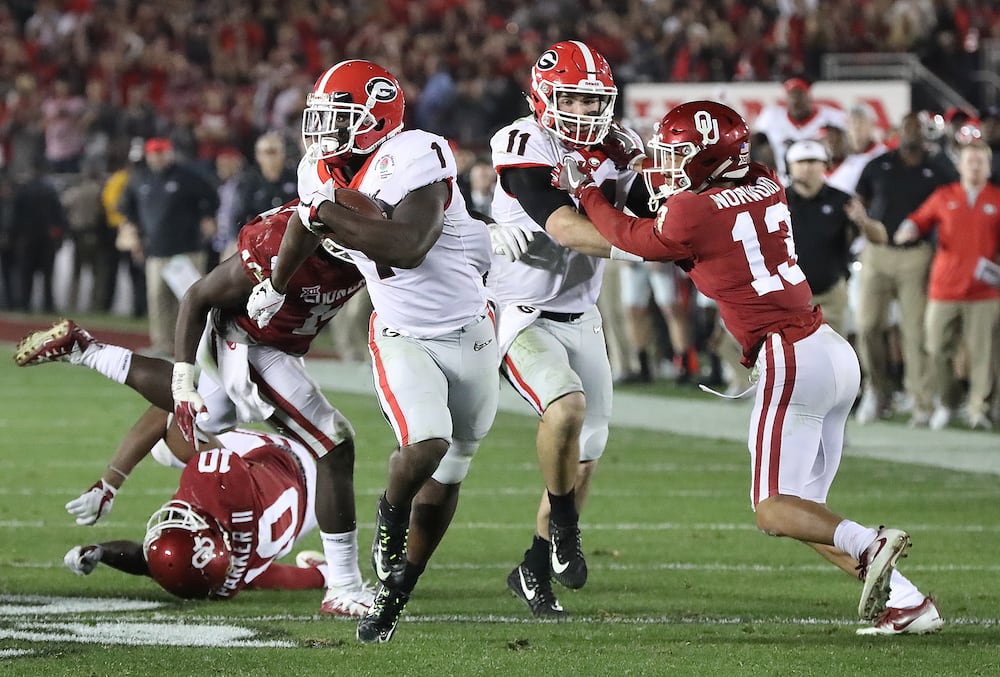 Georgia quarterback Jake Fromm (second from right) throws a key block on Oklahoma cornerback Tre Norwood as tailback Sony Michel heads to the endzone for the winning touchdown during the Rose Bowl on Monday, Jan. 1, 2018, in Pasadena, Calif. (Curtis Compton/AJC)